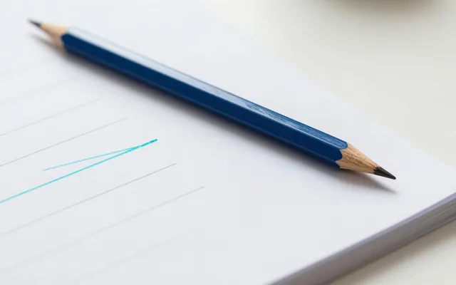 A blue pencil on a printed page with lines struck through